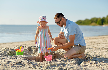 Image showing father and daughter playing with toys on beach