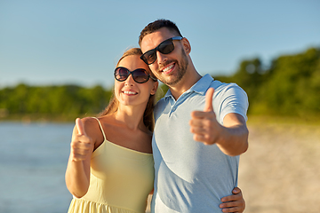 Image showing happy couple showing thumbs up on summer beach