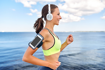 Image showing running woman in headphones with smartphone