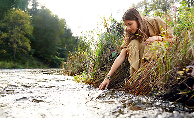 Image showing woman or witch performing magic ritual on river