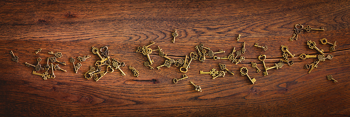 Image showing Magical bronze keys on a wooden oak surface