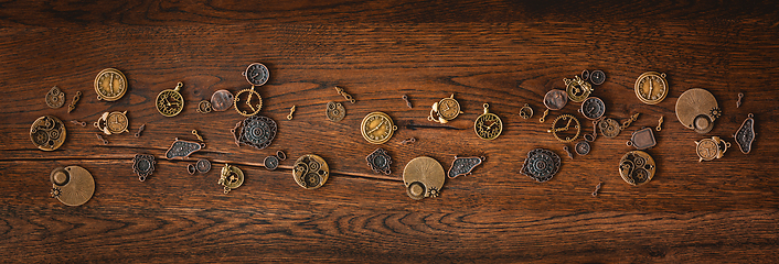 Image showing Mechanical cogwheel elements on a dark wooden surface