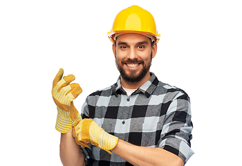 Image showing happy male worker or builder in helmet and gloves