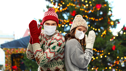 Image showing couple in protective masks and christmas sweaters