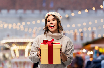 Image showing happy young woman in hat holding chrismas gift