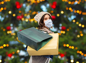 Image showing woman in face mask with shopping bags on christmas