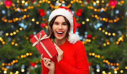 Image showing happy young woman in santa hat with red gift box