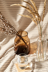 Image showing glass of water, decorative dried flowers in vases