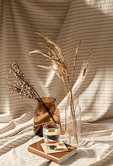 Image showing glass of water, decorative dried flowers in vases