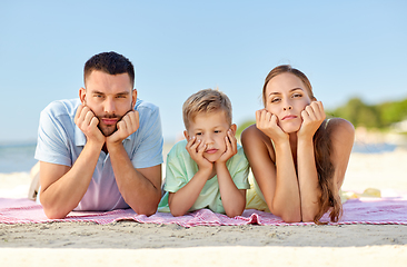 Image showing unhappy family lying on summer beach