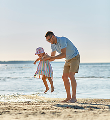 Image showing happy father playing with little daughter on beach