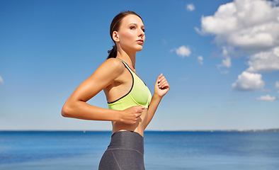 Image showing young woman running at seaside