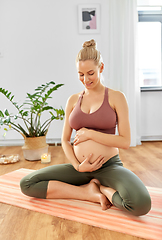 Image showing happy pregnant woman doing yoga at home