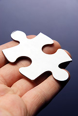 Image showing Hand holding a puzzle piece