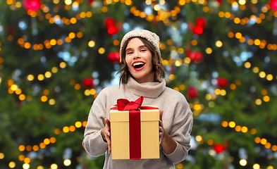 Image showing happy young woman in hat holding chrismas gift