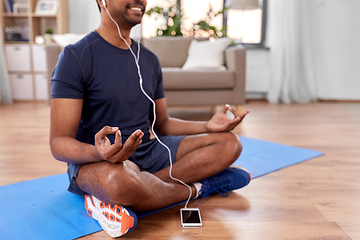 Image showing indian man meditating in lotus pose at home