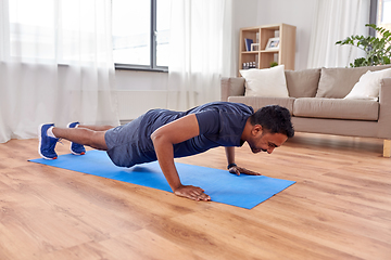 Image showing indian man doing push ups at home