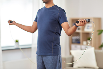 Image showing man exercising with jump rope at home