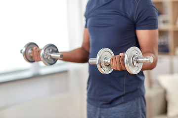 Image showing man exercising with dumbbells at home