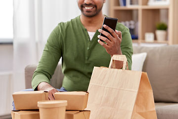Image showing indian man with takeaway food and phone at home