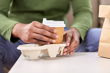 Image showing close up of man with takeaway coffee and food