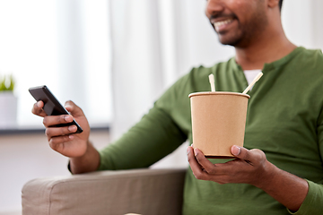 Image showing indian man with phone eating takeaway food at home