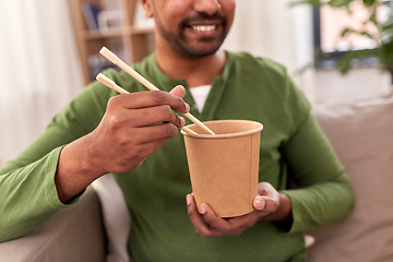 Image showing smiling indian man eating takeaway food at home