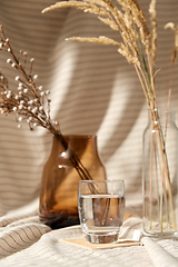 Image showing glass of water, decorative dried flowers in vases