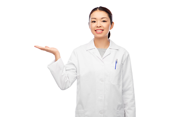 Image showing asian female doctor holding something on hand