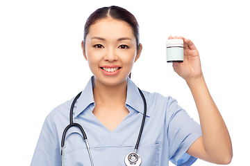 Image showing smiling asian female doctor or nurse with medicine