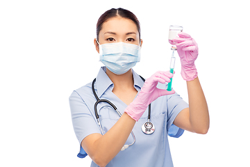 Image showing asian nurse in mask with medicine in syringe