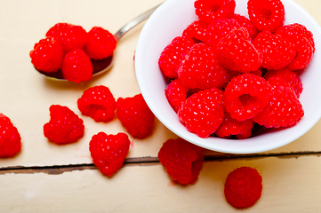 Image showing bunch of fresh raspberry on a bowl and white table