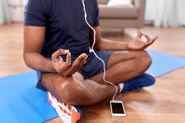 Image showing indian man meditating in lotus pose at home