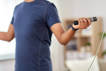 Image showing man exercising with jump rope at home