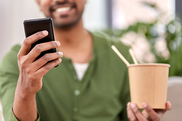 Image showing indian man with phone eating takeaway food at home