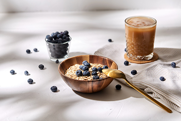 Image showing oatmeal with blueberries, spoon and coffee