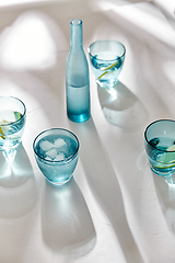 Image showing glasses with water and lemons on white background