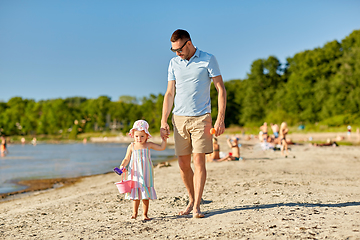 Image showing happy father walking with little daughter on beach