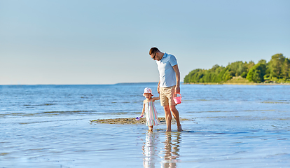 Image showing happy father walking with little daughter on beach