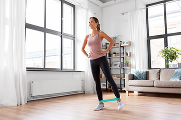 Image showing woman exercising with resistance band at home