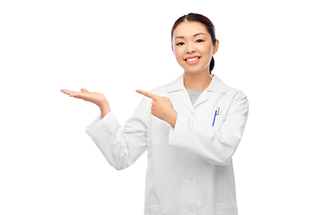 Image showing asian female doctor holding something on hand