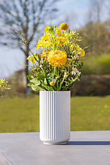 Image showing White vase with yellow wildflowers