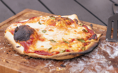 Image showing Homemade pizza on a wooden board