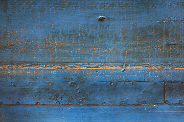 Image showing Rusty blue metal surface with nails