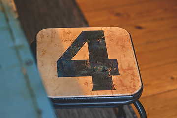 Image showing The number 4 on a small chair in a room