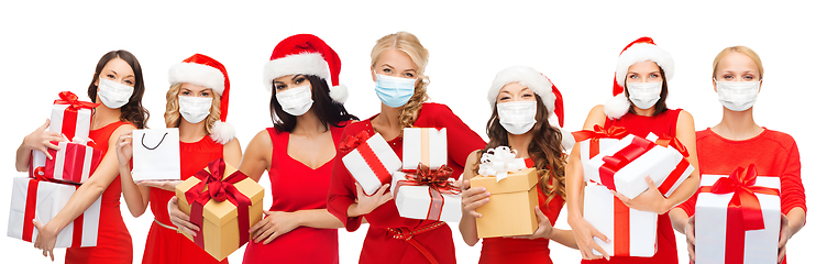 Image showing happy women in medical masks with christmas gifts