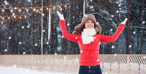 Image showing happy woman in winter fur hat at ice rink