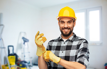 Image showing happy male worker or builder in helmet and gloves