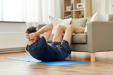 Image showing man making abdominal exercises at home