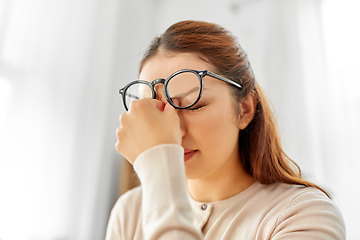 Image showing tired asian woman with glasses rubbing nose bridge